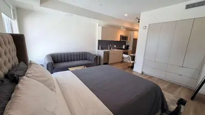 a bedroom with a bed and a couch and a kitchen at Luxury Walk of Fame Studio in Los Angeles