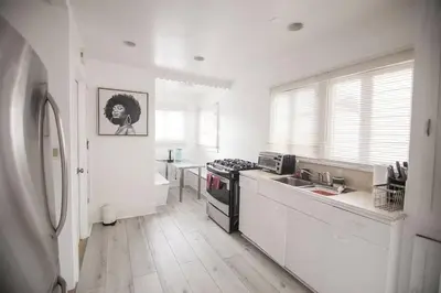 a white kitchen with a sink and a stove at Private Room in East Hollywood in Los Angeles