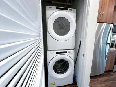 a washer and dryer in a kitchen next to a refrigerator at Modern Cosmopolitan APT Mid Hollywood with Free Parking 10mins to Universal Studios in Los Angeles