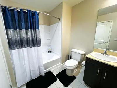a bathroom with a toilet and a sink and a shower at Mid Century With Pool GYM and Parking 10min to Cedars in Los Angeles