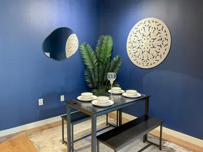 a blue room with a table with plates and a plant at Mid Century With Pool GYM and Parking 10min to Cedars in Los Angeles