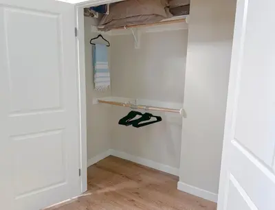 a closet with white walls and a wooden floor at Mid Century With Pool GYM and Parking 10min to Cedars in Los Angeles