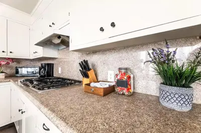 a kitchen with white cabinets and a counter top at Spacious 4 bedroom home by Melrose and 10 minutes to Hollywood Walk of Fame in Los Angeles