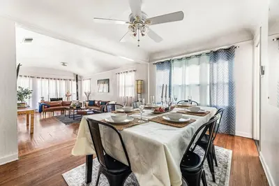 a dining room table with chairs and a ceiling fan at Spacious 4 bedroom home by Melrose and 10 minutes to Hollywood Walk of Fame in Los Angeles