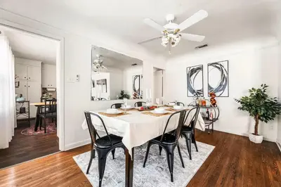 a dining room with a white table and chairs at Spacious 4 bedroom home by Melrose and 10 minutes to Hollywood Walk of Fame in Los Angeles