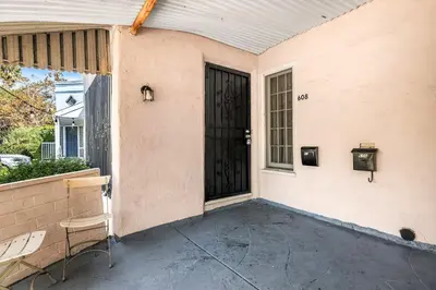 a porch with a black door and a chair at Spacious 4 bedroom home by Melrose and 10 minutes to Hollywood Walk of Fame in Los Angeles