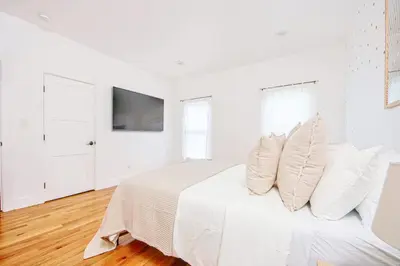 a white bedroom with a bed with white pillows at Inviting 3BR Home with Porch & Greenery in Los Angeles