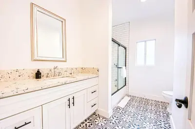 a white bathroom with a sink and a toilet at Inviting 3BR Home with Porch & Greenery in Los Angeles