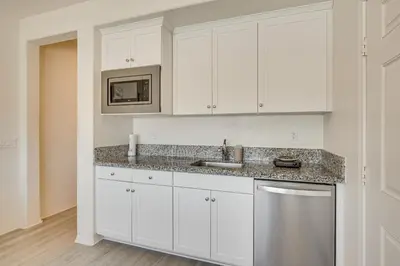 a kitchen with white cabinets and a sink at Cozy Desert Sanctuary 9 Mi to Mojave Narrows Park! in Victorville