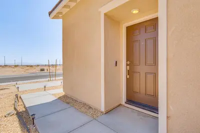 a door to a house with the ocean in the background at Cozy Desert Sanctuary 9 Mi to Mojave Narrows Park! in Victorville