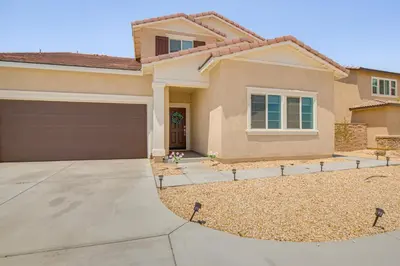 a house with a garage in front of it at Cozy Desert Sanctuary 9 Mi to Mojave Narrows Park! in Victorville