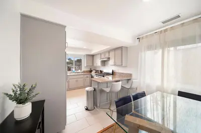 a kitchen and living room with a glass table at Bay Breeze Hideaway in Lawndale
