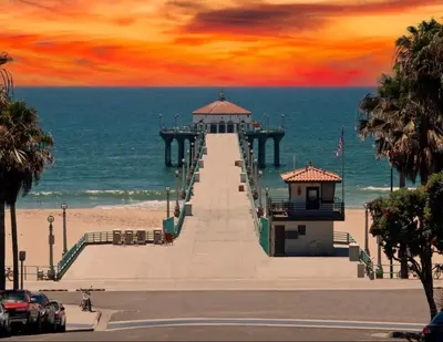 a pier on the beach with a sunset at Bay Breeze Hideaway in Lawndale