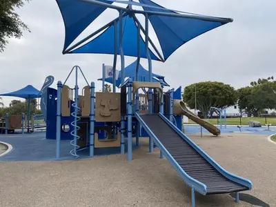 a playground with a slide and an umbrella at Exquisite 2BDRM in Heart of MDR King Bed in Los Angeles