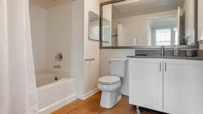 a white bathroom with a tub and a toilet and a sink at Exquisite 2BDRM in Heart of MDR King Bed in Los Angeles