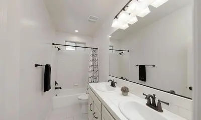 a white bathroom with a sink and a mirror at Modern 3BR Home Gated Community in Bakersfield