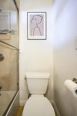 a bathroom with a toilet and a picture on the wall at Near LA Cozy Home with Full Kitchen & Laundry in San Gabriel
