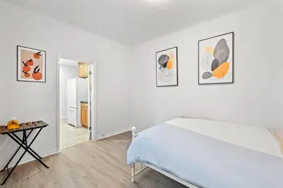 a white room with a bed and four pictures on the wall at Near LA Cozy Home with Full Kitchen & Laundry in San Gabriel