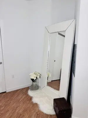 a mirror on a wall next to a vase with flowers at The Hollywood loft FREE Parking in Los Angeles