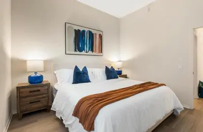 a bedroom with a large white bed with blue pillows at The Sunstone - Full Oceanview Right On The Sand in Los Angeles
