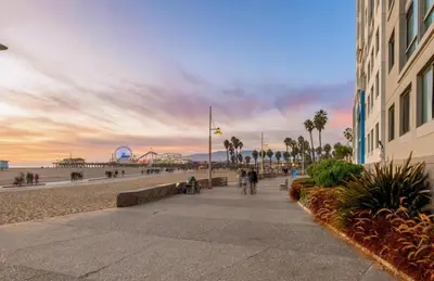 a sidewalk next to a beach with a building at The Sunstone - Full Oceanview Right On The Sand in Los Angeles