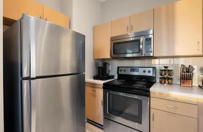 a kitchen with a stainless steel refrigerator and a microwave at The Sunstone - Full Oceanview Right On The Sand in Los Angeles
