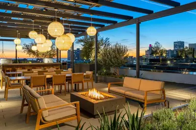 a patio with tables and chairs and a fire pit at The Sunstone - Full Oceanview Right On The Sand in Los Angeles