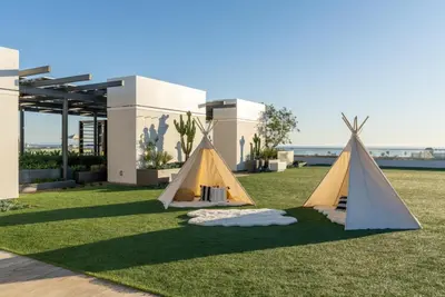 two tents on a lawn in front of a house at The Sunstone - Full Oceanview Right On The Sand in Los Angeles