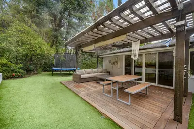 a patio with a table and a couch on a deck at Hillside Modern Retreat with pool BBQ and MORE in Los Angeles