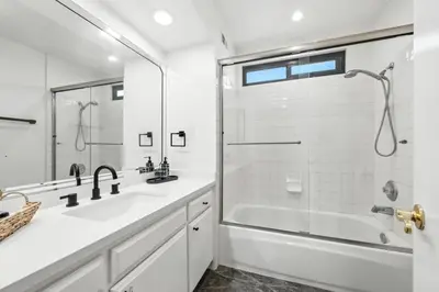 a white bathroom with a tub and a sink and a shower at Burbank Bliss Retreat in Los Angeles