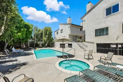 a pool with chairs and an umbrella in a yard at Burbank Bliss Retreat in Los Angeles