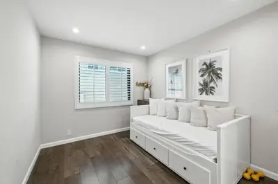 a white bedroom with a white bed and two windows at Burbank Bliss Retreat in Los Angeles
