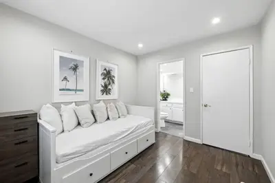 a white bedroom with a bed and a bathroom at Burbank Bliss Retreat in Los Angeles