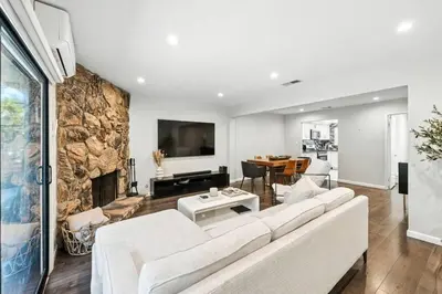 a living room with a white couch and a stone wall at Burbank Bliss Retreat in Los Angeles