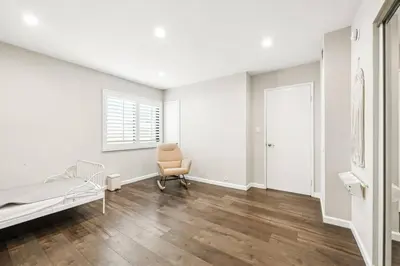a white room with a bed and a chair in it at Burbank Bliss Retreat in Los Angeles
