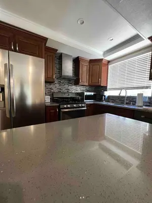 a kitchen with wooden cabinets and a stainless steel refrigerator at Beautiful and cozy! in Palmdale