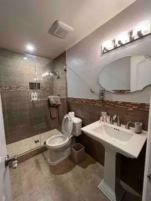 a bathroom with a toilet and a sink and a shower at Beautiful and cozy! in Palmdale
