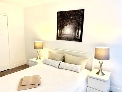 a bedroom with a white bed and two lamps at Western Sierra Vista in Los Angeles