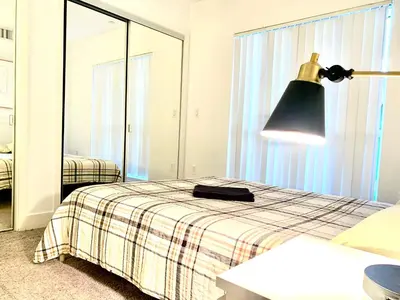 a bedroom with a bed with a lamp and a mirror at Western Marathon in Los Angeles