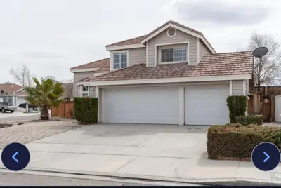 a house with a garage with arrow signs in front at Desert View in Victorville