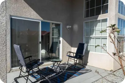 three chairs sitting on a patio next to a building at Desert View in Victorville