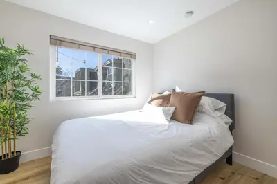 a bedroom with a bed with white sheets and a window at Moonlight Ridge Jacuzzi, Gated, EV Charge, Cent AC in Big Bear City Airport