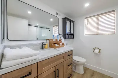 a bathroom with a sink and a toilet and a mirror at Moonlight Ridge Jacuzzi, Gated, EV Charge, Cent AC in Big Bear City Airport