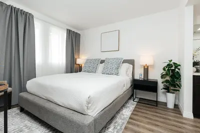 a bedroom with a white bed and a couch at Cozy 2BD apartment in Los Angeles