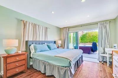a bedroom with a bed and a desk and a window at Modern Pool house with hot tub and relaxing backyard in Long Beach