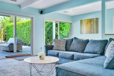 a living room with a blue couch and a table at Modern Pool house with hot tub and relaxing backyard in Long Beach