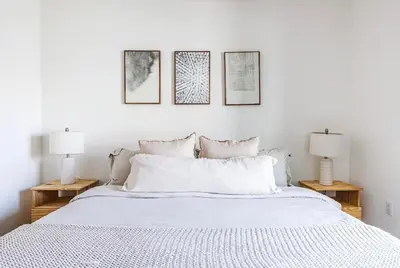 a bedroom with a white bed with three pictures on the wall at Beautiful Apartment in Hollywood in Los Angeles