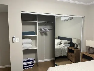 a bedroom with a closet with a bed and a mirror at Guest House in Torrance