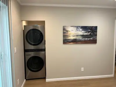 a room with a washing machine next to a painting at Guest House in Torrance