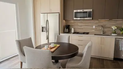 a kitchen with a table and chairs and a refrigerator at Modern Boutique Living in Culver City in Los Angeles